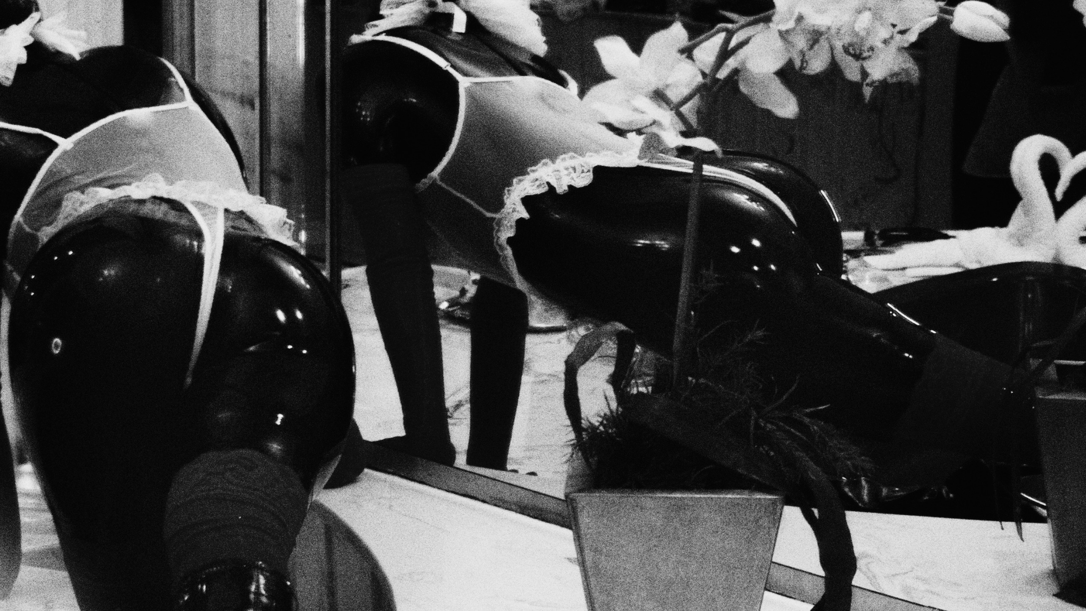 A figure crawling, covered in latex and lace