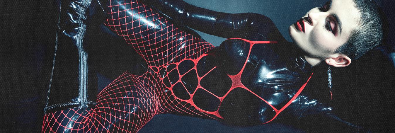 Dominatrix latex catsuit femdom fishnet red lipstick
